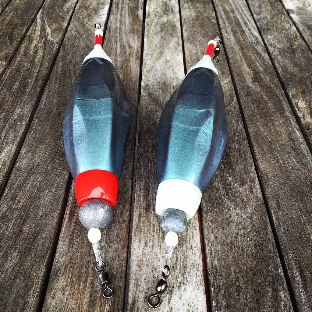 Two fishing floats with red and white ends and sinkers 